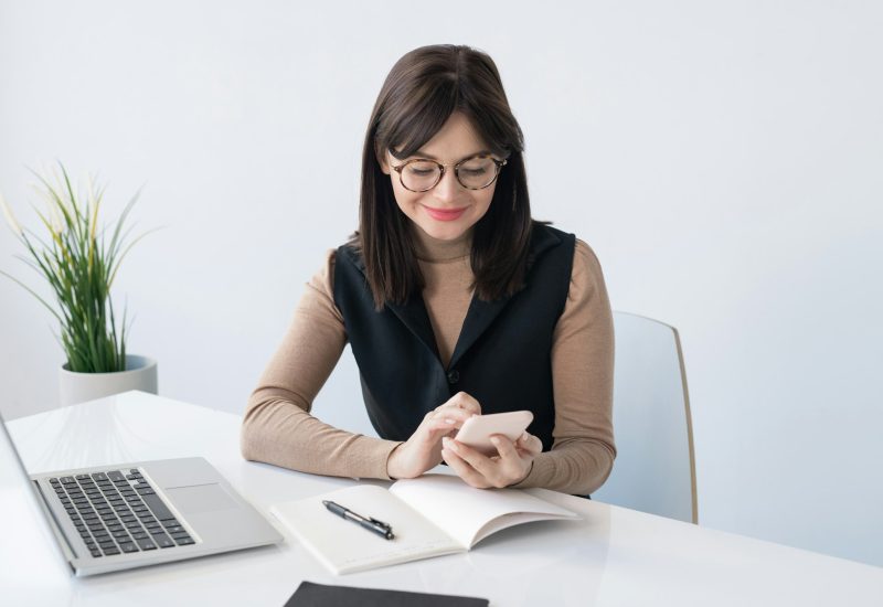 young-teacher-or-businesswoman-with-smartphone-over-open-copybook.jpg